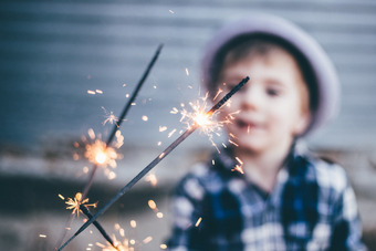 Kind mit Wunderkerzen im Freien – festliche Stimmung mit Lichteffekten und unscharfem Hintergrund für besondere Momente