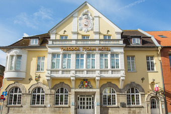 Theodor Storm Hotel mit gelber Fassade, historischen Fenstern und modernem Anbau – stilvolle Unterkunft in zentraler Lage